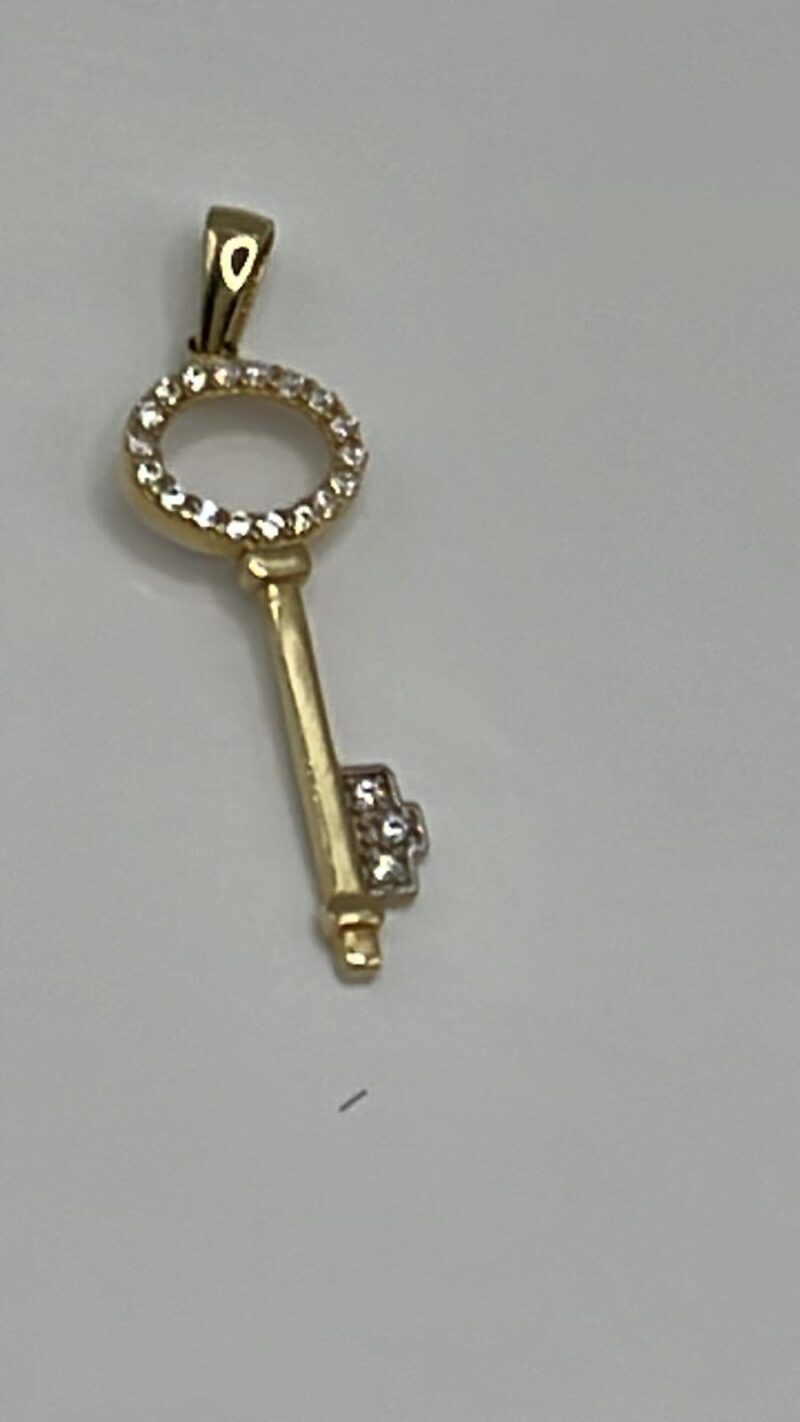 Dije de llave  en oro amarillo con piedras blancas