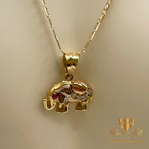 Dije de elefante oro rosa y amarillo piedras blancas y una roja